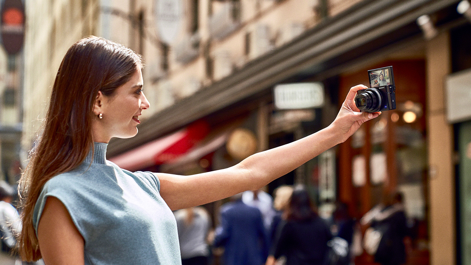 A woman taking a selfie with her Sony's RX100 Mark VI 